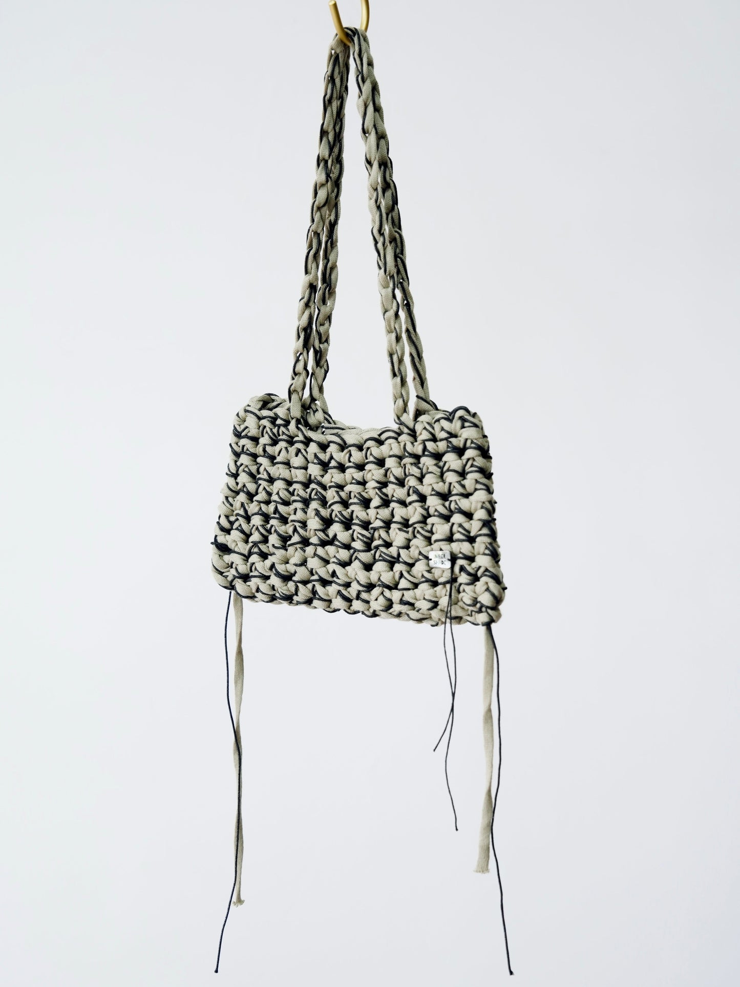 Woven handbag with long straps on a white background