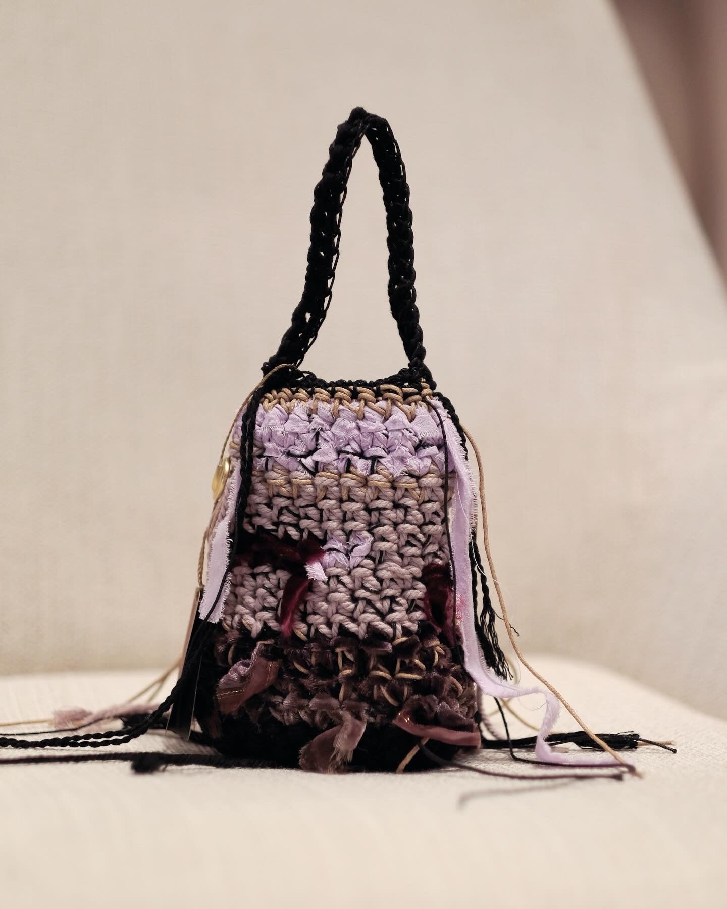 Crocheted handbag with tassels on a light background