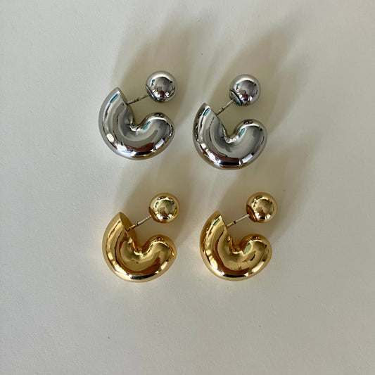 Pair of gold and silver earrings on a white background