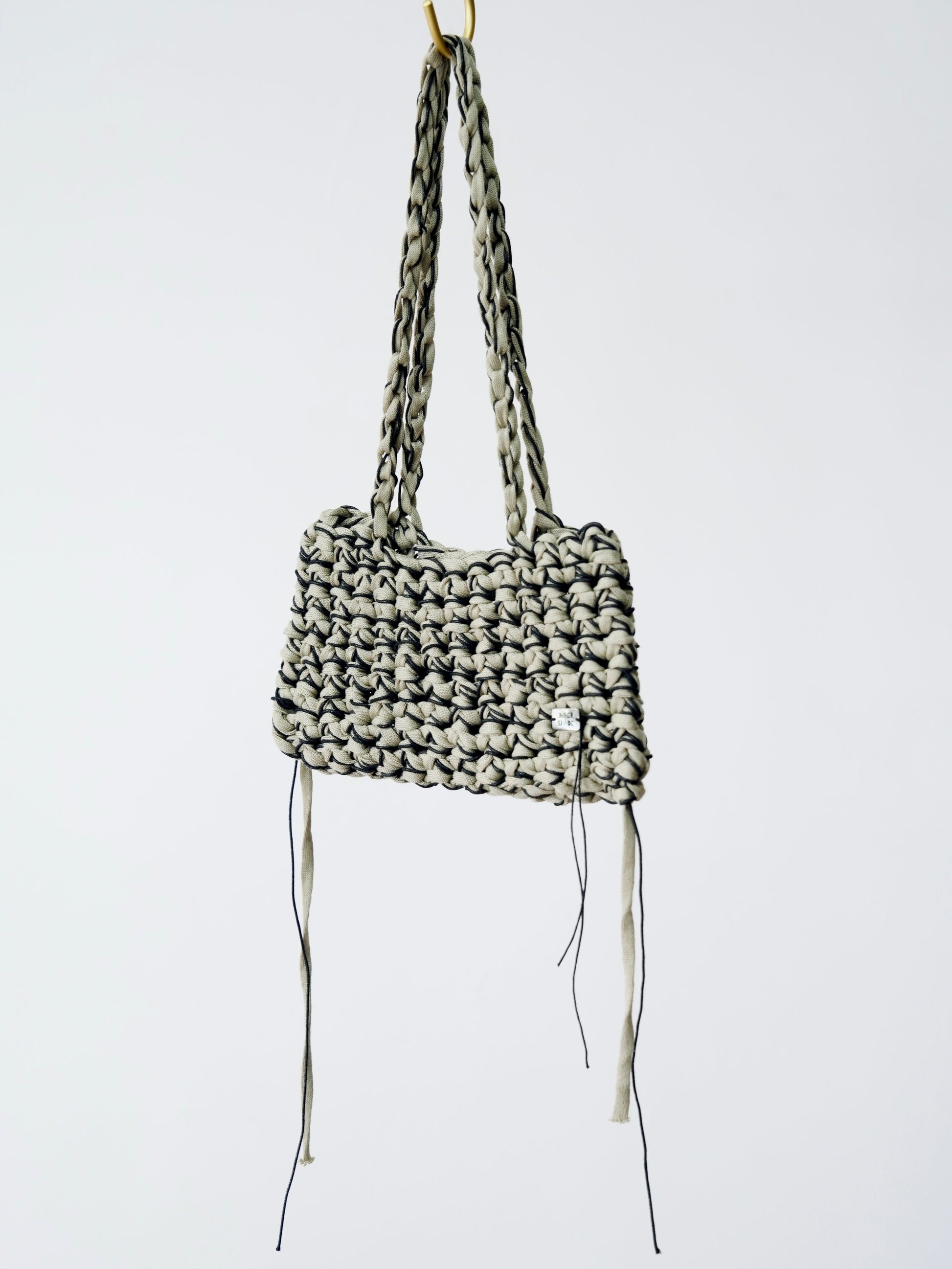 Woven handbag with long straps on a white background