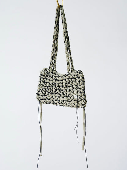 Woven handbag with long straps on a white background